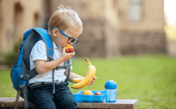 A kid is eating fruits after school
