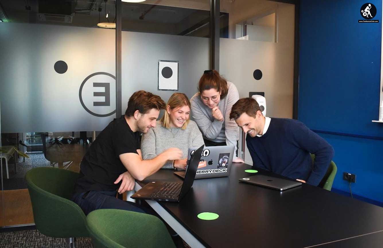 Four people smiling and looking at a laptop after implementing effective account planning strategies.